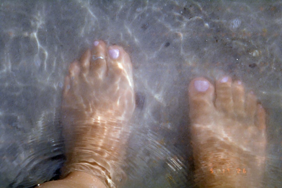 Pies con las uñas pintadas sumergidos en agua