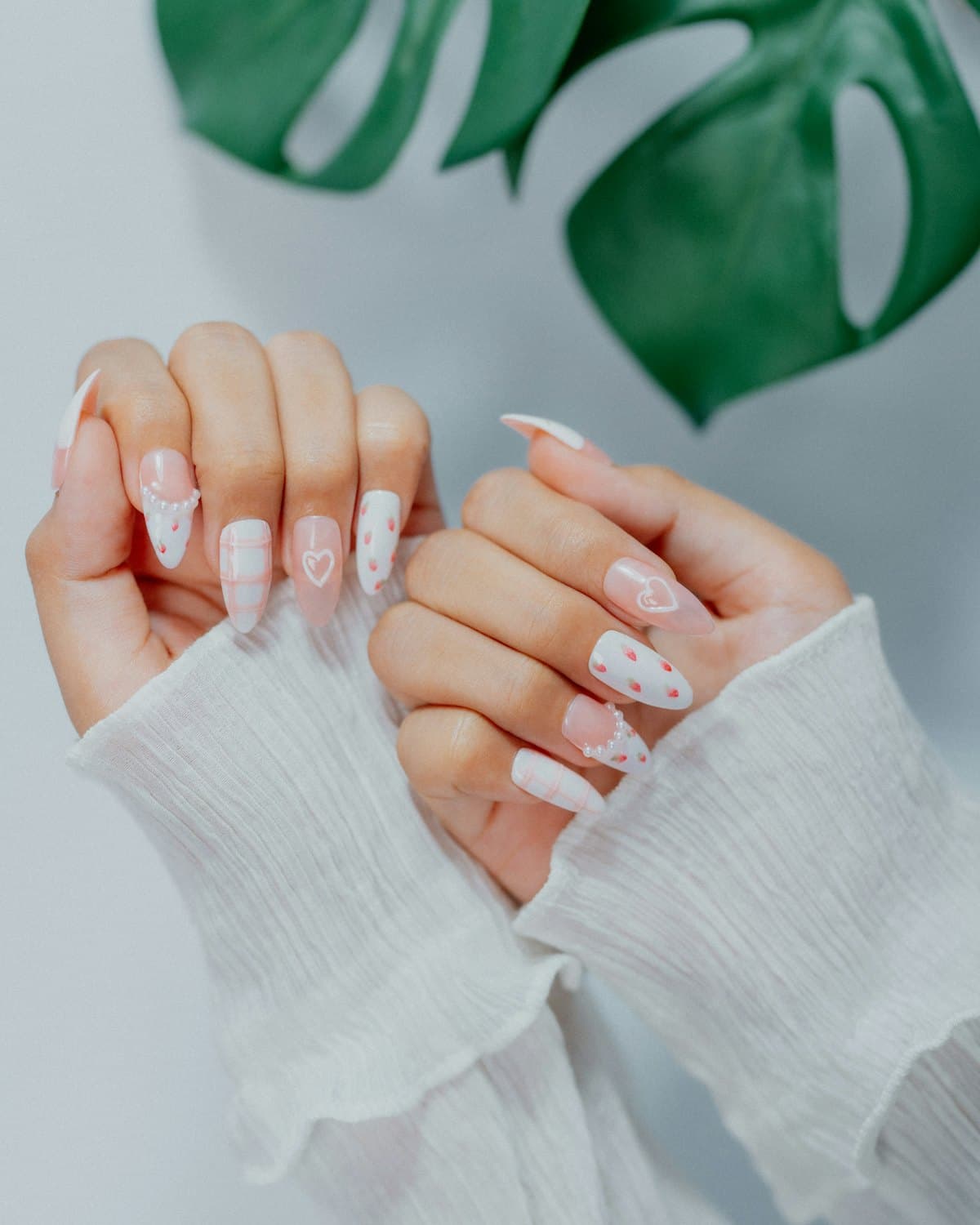 Uñas largas blancas y rosas con detalles de corazón